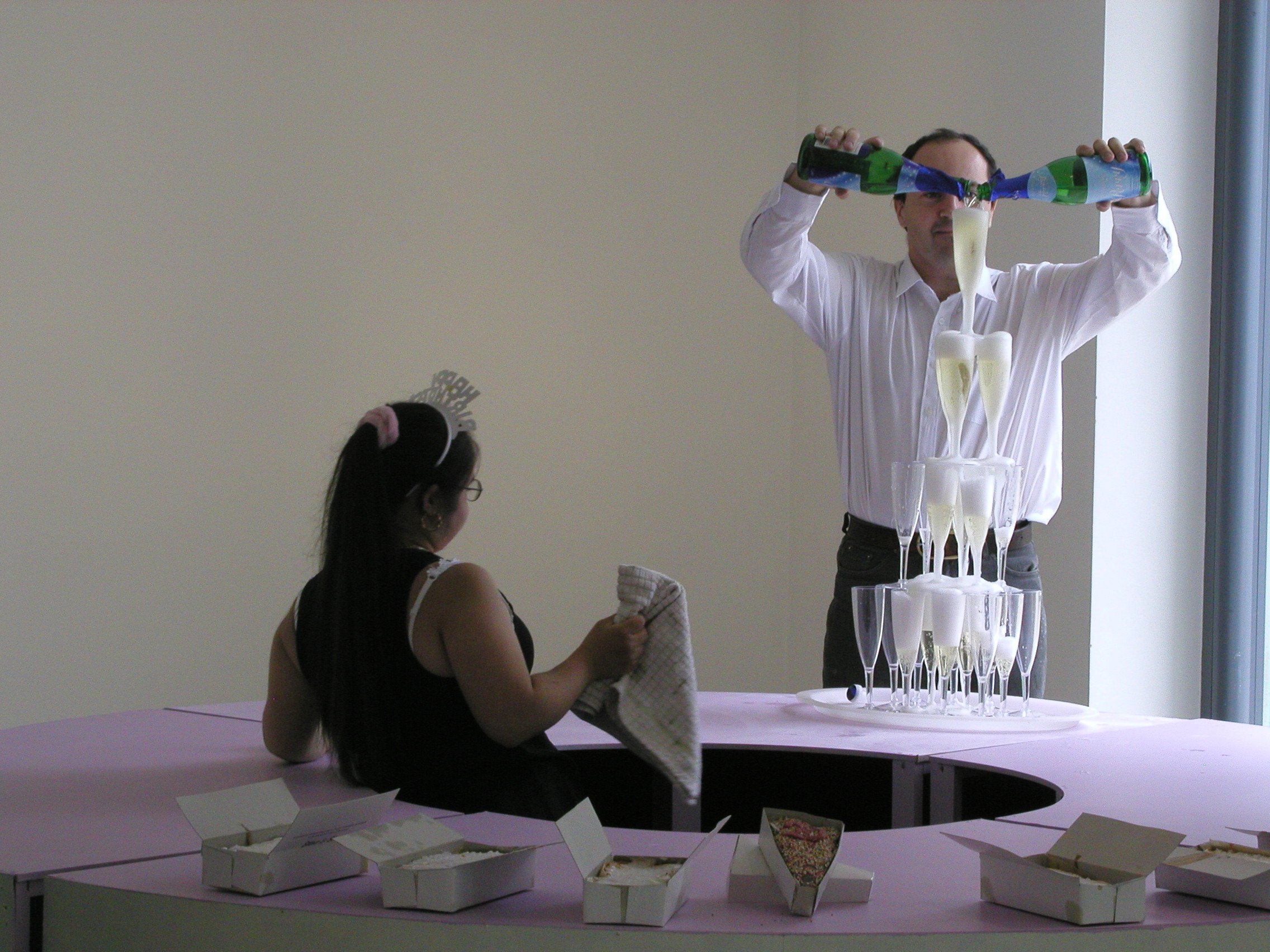 Photo of Aisha with Charlie Fox in front of a fountain of Champagne glasses